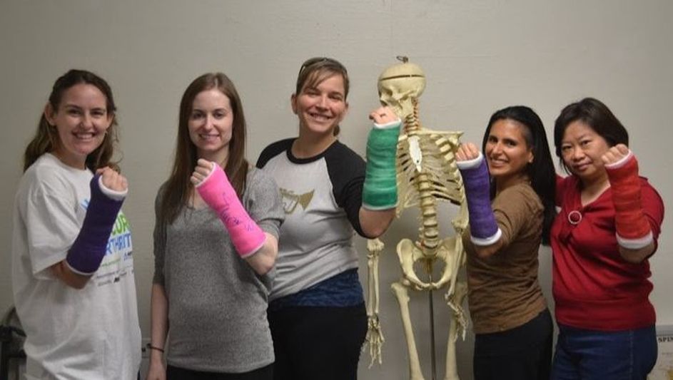 Five orthopedic nurses hold up their casts to showcase nursing education